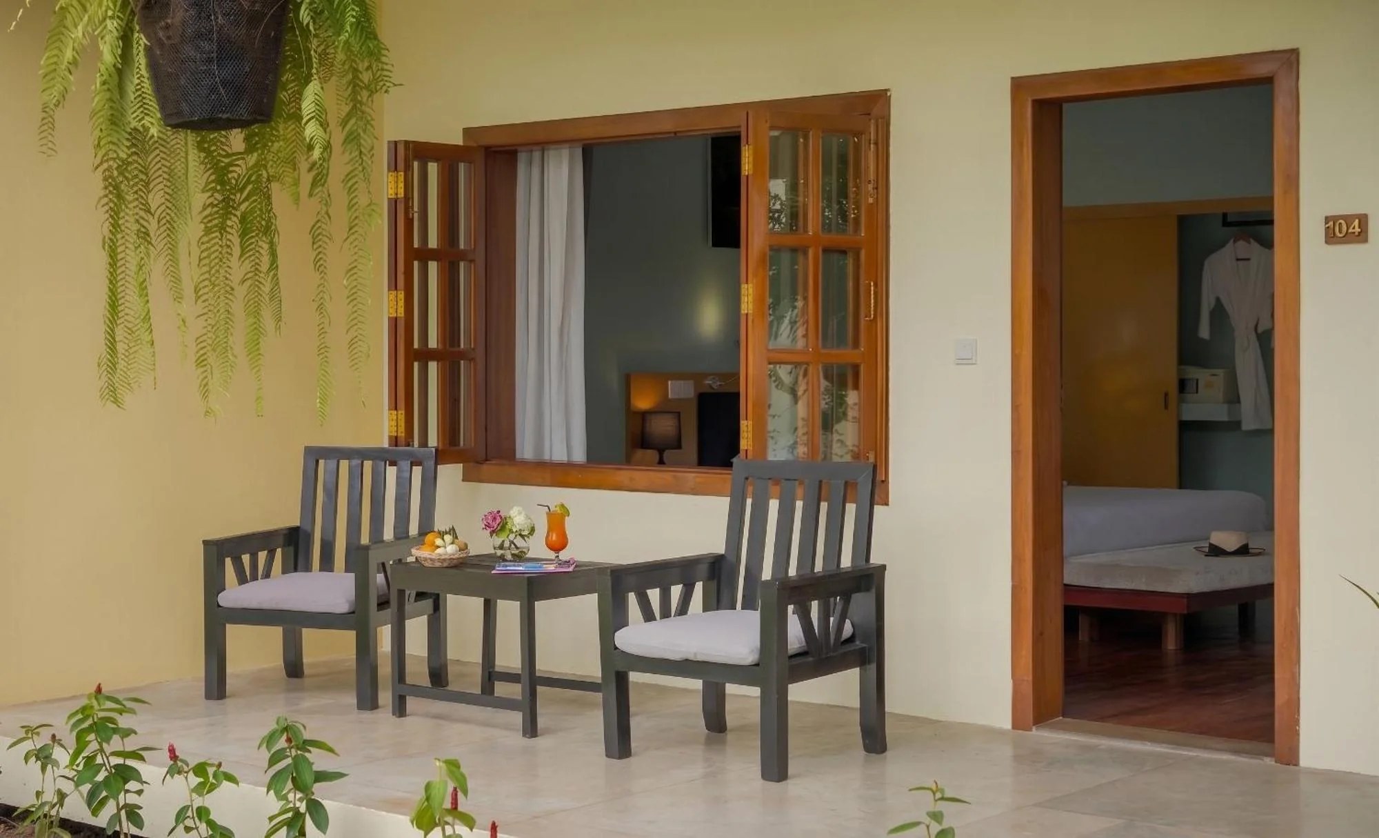 A shaded terrace with wooden seating and tropical greenery at the resort
